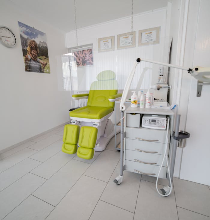 Comfortable couch for clients and medicines placed on table behind protective screen during coronavirus pandemic in cosmetologist office